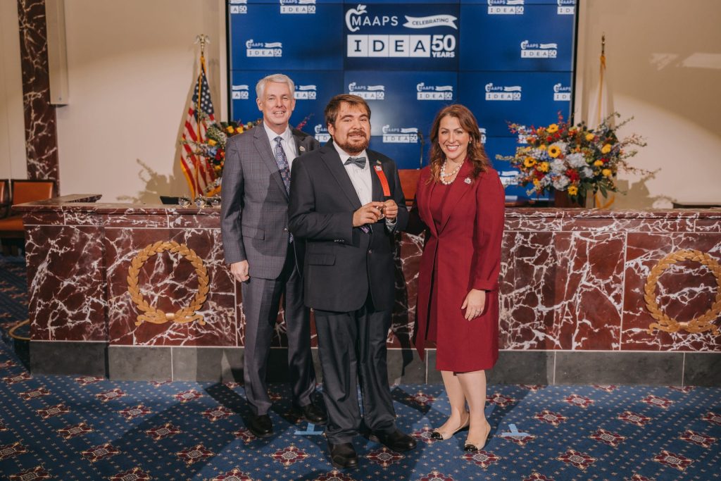 Student Ambassador Liam from New England Center for Children presents an IDEA Award to Sen. John F. Keenan, pictured with MAAPS Executive Director, Elizabeth Becker.